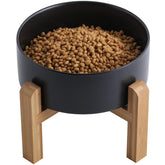 Addogyy black elevated ceramic dog bowl with wood stand for easy access at mealtime.