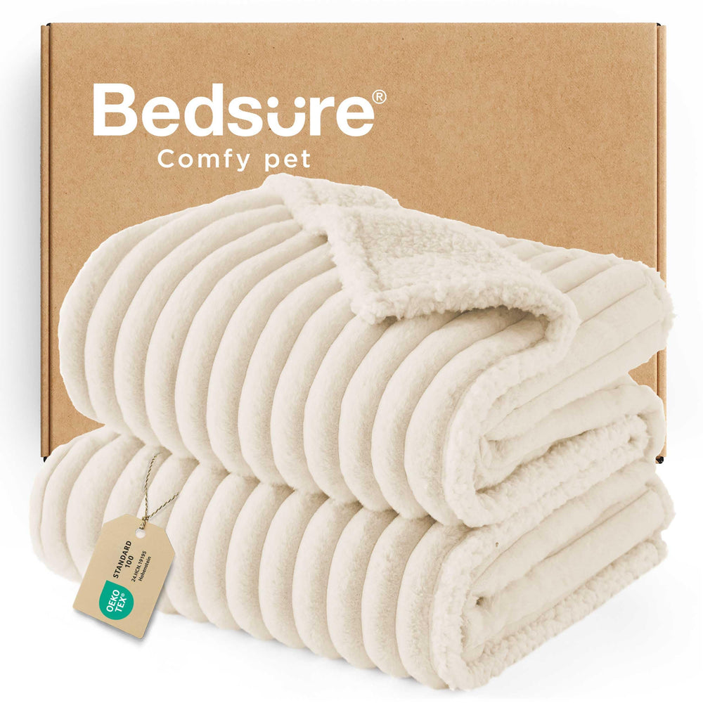 Bedsure ComfyFleece waterproof blanket on a large cream couch for protection