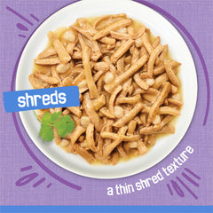 Friskies Shreds Turkey Dinner in Gravy with cheese topping close-up highlights added flavor.