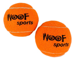 Woof Sports bright orange tennis balls visible in grass during play