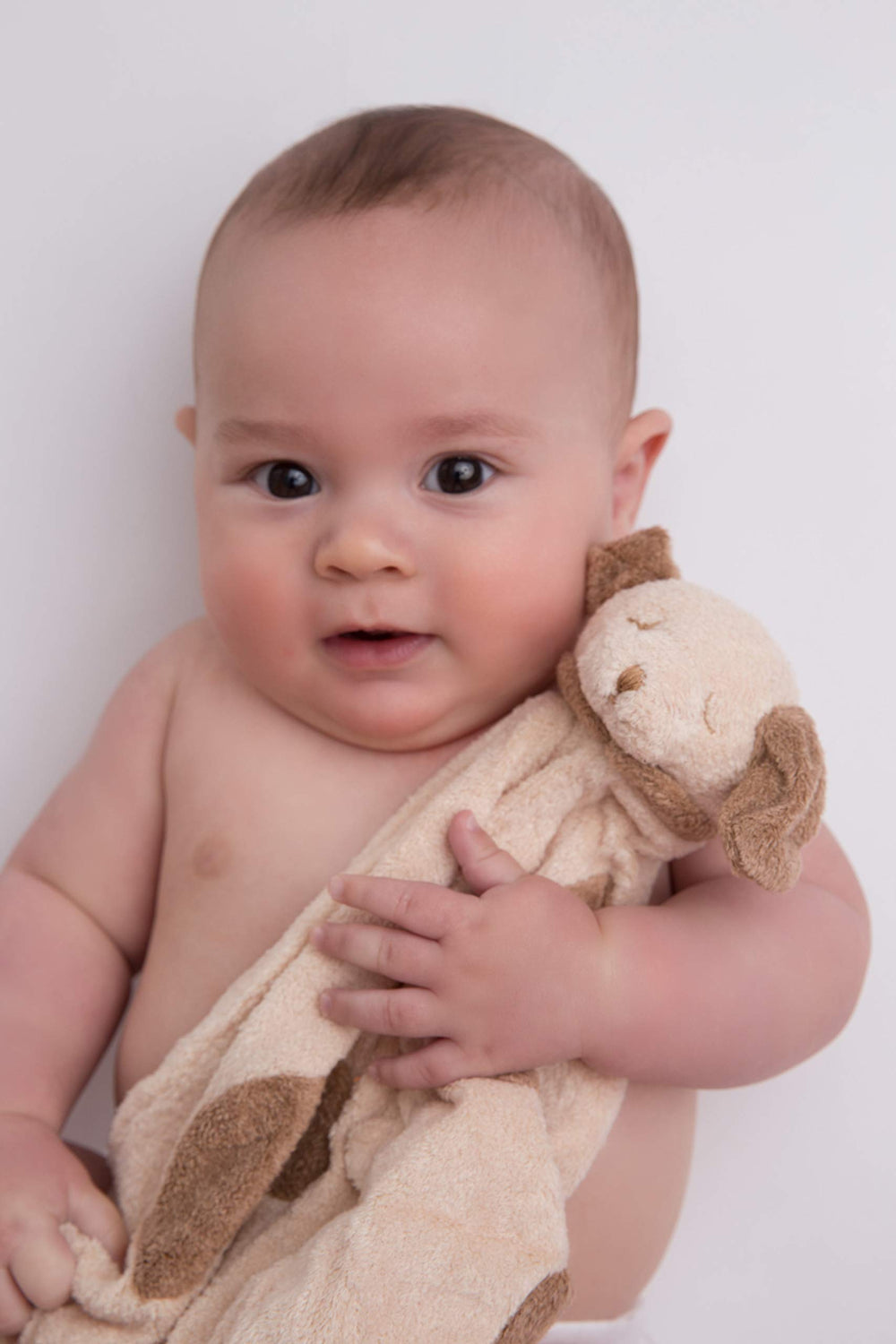 Angel Dear light brown puppy blankie in a nursery setting for on-the-go companionship.