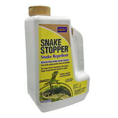 Bonide Snake Stopper being applied in a garden near plants to deter snakes