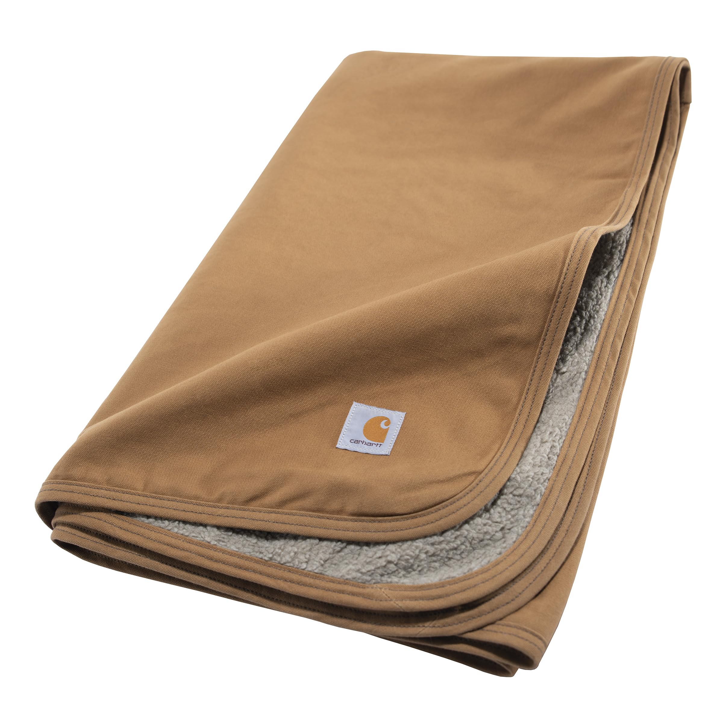 Carhartt Firm Duck Sherpa-Lined Blanket draped on a couch, stays flat and furniture-friendly.