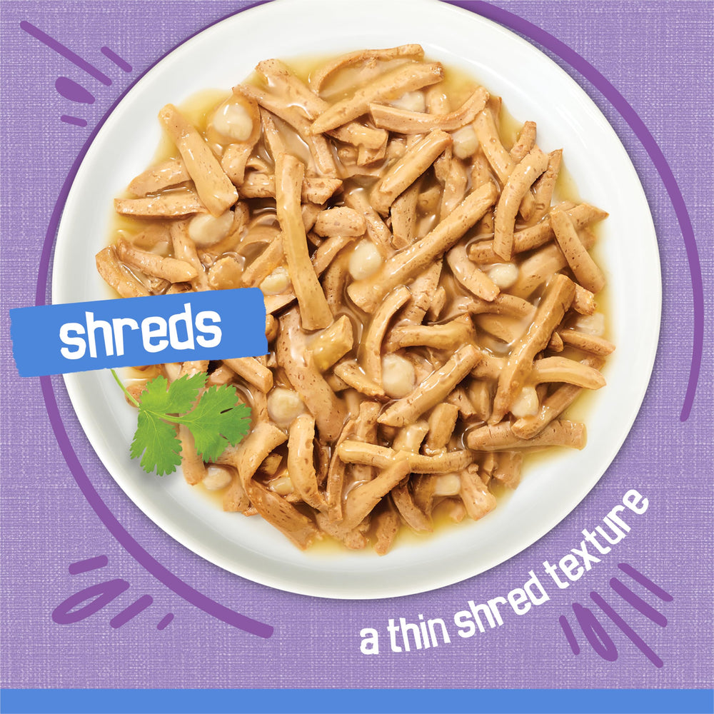 Friskies Shreds Turkey Dinner in Gravy with cheese topping close-up highlights added flavor.