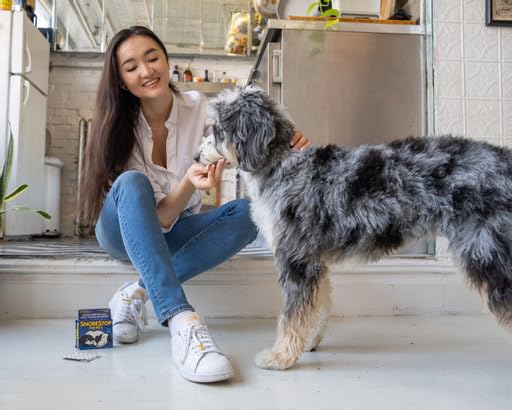 Pet resting calmly beside SnoreStop for Pets bottle on a countertop.